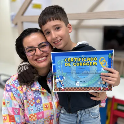 Profissional de óculos e menino com certificado de coragem azul.
