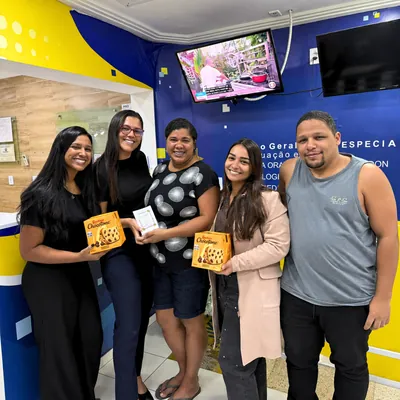 Cinco pessoas reunidas na recepção da clínica.